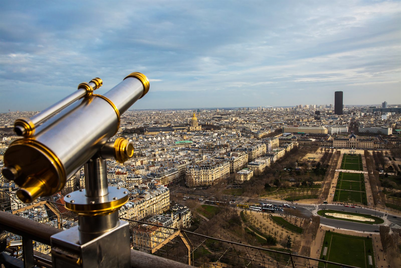 Brass coin-operated telescope overlooking the rooftops of Paris, like a travel agent newsletter that scans the whole industry